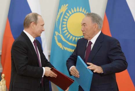 Russian President Vladimir Putin, left, and Kazakh President Nursultan Nazarbayev exchange documents during a signing ceremony after their talks in Astana, Kazakhstan, on Thursday.
