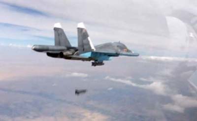 Photo shows a Russian Su-34 fighter-bomber dropping a bomb in the air over Syria.