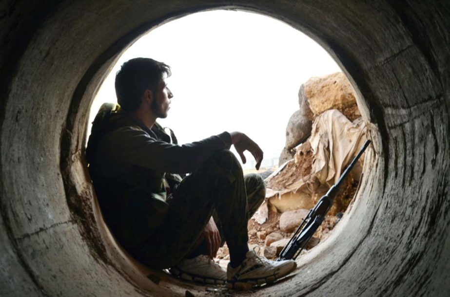 A rebel fighter rests during clashes with pro-government forces on the outskirts of the central Syrian province of Homs.