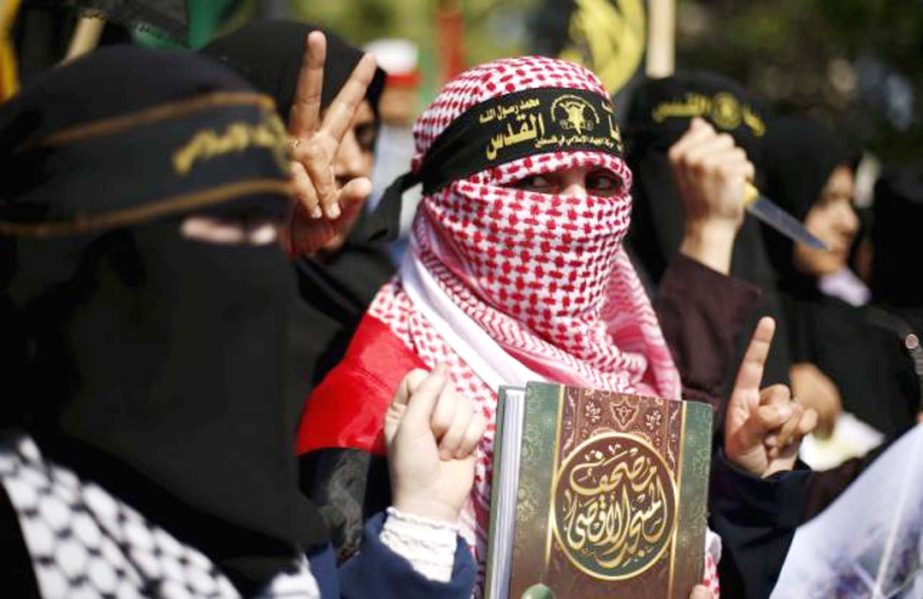 A Palestinian woman supporting the Islamic Jihad movement holds a copy of the Koran as she takes part in a rally in Gaza City to show solidarity with Palestinians confronting Israelis in the West Bank and Jerusalem on Tuesday.