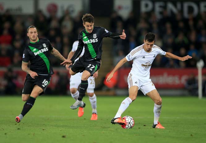 Stoke City's Bojan Krkic (center) and Swansea City's Jack Cork battle for the ball during their English Premier League soccer match at the Liberty Stadium, Swansea, Wales on Monday.