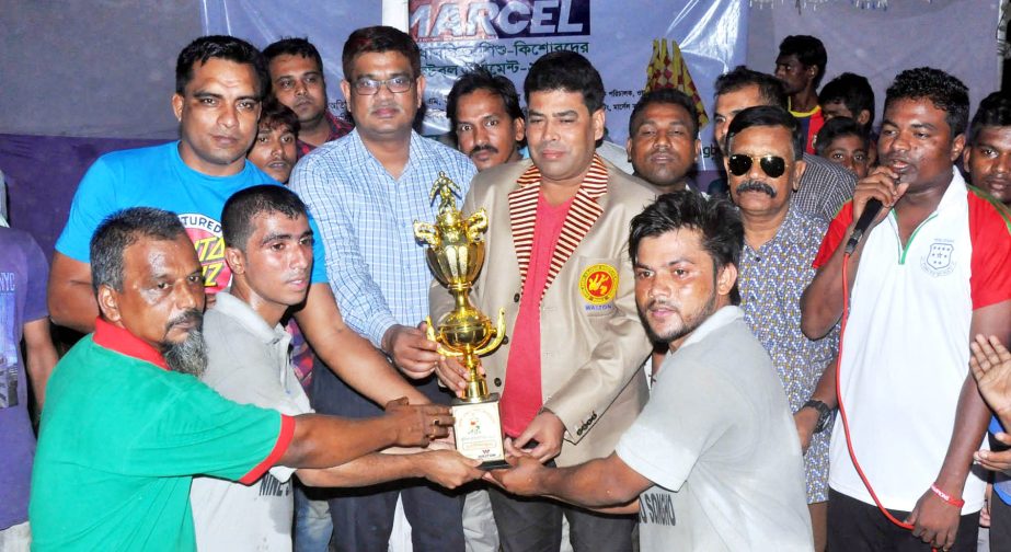 First Senior Additional Director of Walton FM Iqbal Bin Anwar Dawn handing over the trophy to Nine Star, the champions of the football tournament for under privileged children at the Paltan Maidan on Tuesday.
