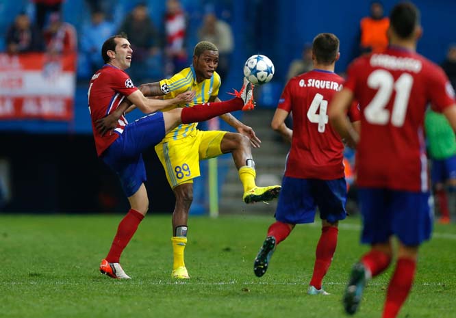 Atletico's Diego Godin (left) fights for the ball with Astana's Junior Kabananga during the Champions League group C soccer match between Atletico Madrid and Astana at the Vicente Calderon stadium in Madrid on Wednesday.