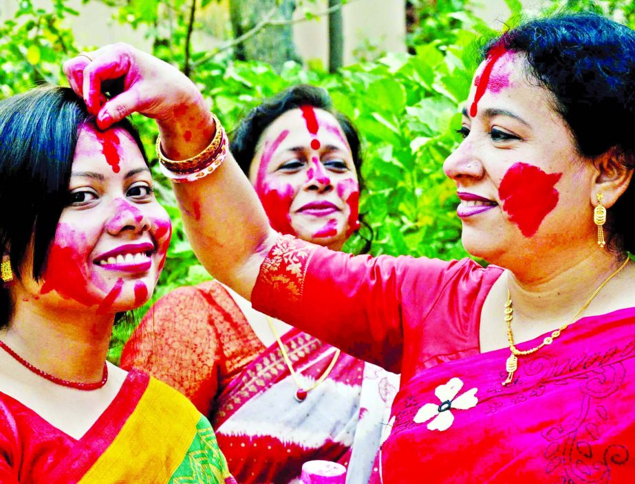 A woman of the Hindu community anoint vermilion on another's forehead seeking blessings of Goddess Durga on the occasion of 'Bijoya Dashami'. The snap was taken from Dhakeshwari Jatiya Mandir on Friday.