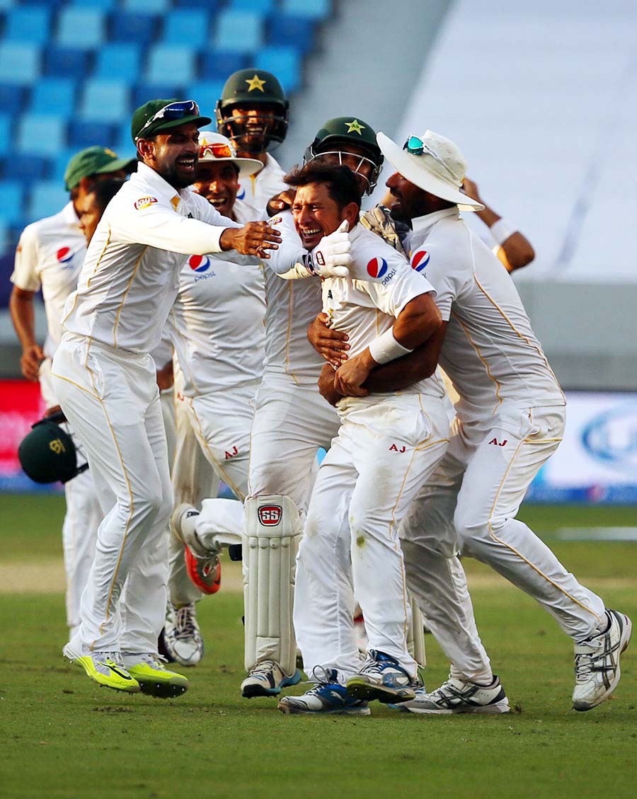 Pakistan's fielders mob Yasir Shah after Pakistan's thrilling win against England in 2nd Test at Dubai on Monday.