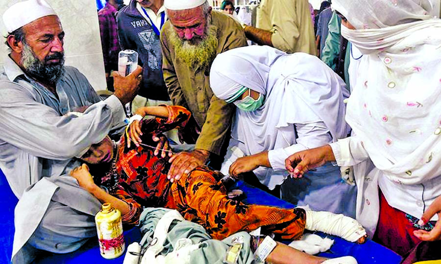 Paramedics treat a girl injured in an earthquake at a hospital in Peshawar.