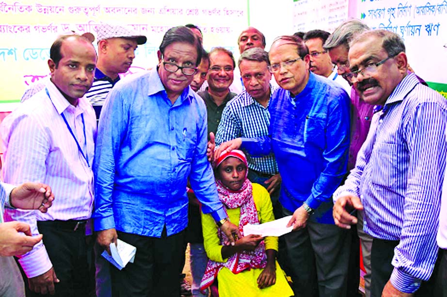 Bangladesh Bank Governor Dr Atiur Rahman and Managing Director of Bangladesh Development Bank Limited Dr Md. Zillur Rahman handing over a cheque for a wheel chair to a physically challenged resident Rikta Begaum of now defunct enclave Gedaldah, Dimlah at