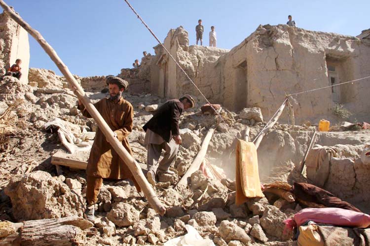 Residents clear the rubble of a house after it was damaged by an earthquake in Peshawar, on Tuesday.