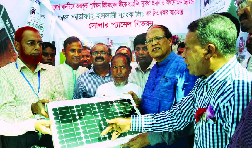 Bangladesh Bank Governor Dr Atiur Rahman handing over solar panels among the former-enclave peoples in northern district of Panchagarh at a function organized by Al-Arafah Islami Bank Limited recently.