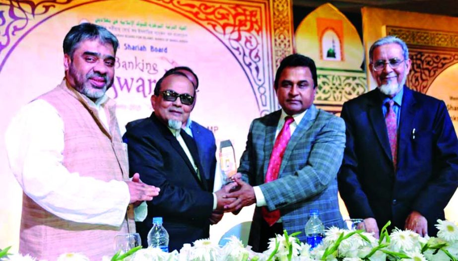 Planning Minister AHM Mustafa Kamal MP, handing over 'Islami Banking Award' conferred by Central Shari'ah Board for Islamic Banks of Bangladesh to Engr Mustafa Anwar, Chairman of Islami Bank Bangladesh Limited at a hotel in the city on Wednesday. MA Ma