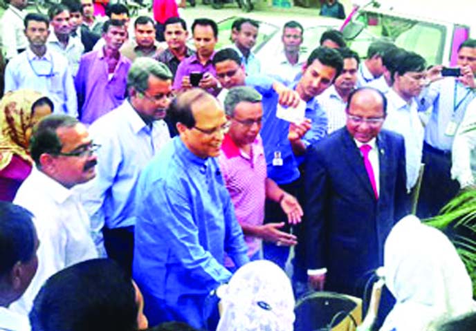 Bangladesh Bank Governor Dr Atiur Rahman handing over a Mutual Trust Bank (MTB)-donated cheque for Tk 2.0 million to UNO, Debiganj, Panchagarh, Mohammod Shafiqul Islam for building a secondary school at Garati, a former enclave in Panchagarh, at a ceremon