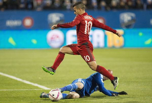 Toronto FC's Sebastian Giovinco leaps over a tackle by Montreal Impact's Laurent Ciman during second-half MLS soccer playoff action in Montreal on Thursday.