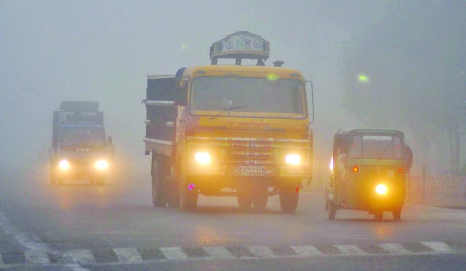 Foggy winter weather on the Dhaka-Aricha Highway forcing vehicles to ply with headlights in the morning. This photo was taken at 12 noon on Friday.