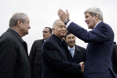 Uzbek Foreign Minister Abdulaziz Kamilov, left, looks on while Uzbek President Islam Karimov, centre, and U.S. Secretary of State John Kerry, right, shake hands at Samarkand Airport in Samarkand, Uzbekistan on Sunday.