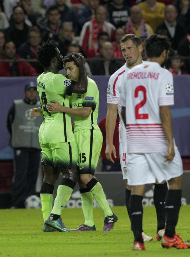 Manchester City's Wilfried Bony (left) celebrates with Jesus Navas after scoring his team's 3rd goal during the Group D Champions League soccer match between Sevilla and Manchester City at the Ramon Sanchez-Pizjuan stadium in Seville, Spain on Tuesday.