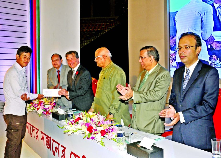 Finance Minister Abul Maal Abdul Muhith, MP, handing over the Scholarship Awarding Letters to the DBBL scholarship recipients at Shaheed Surhawardy Indoor Stadium, Mirpur, Dhaka on Saturday. Law Minister Anisul Huq, MP and Benoit-Pierre Laramee, High Comm