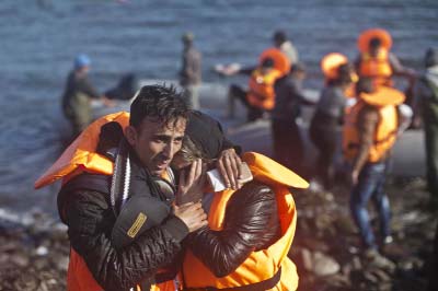 A man hugs his spouse after travelling by boat to a beach on the northern shore of Lesbos, Greece on Saturday.