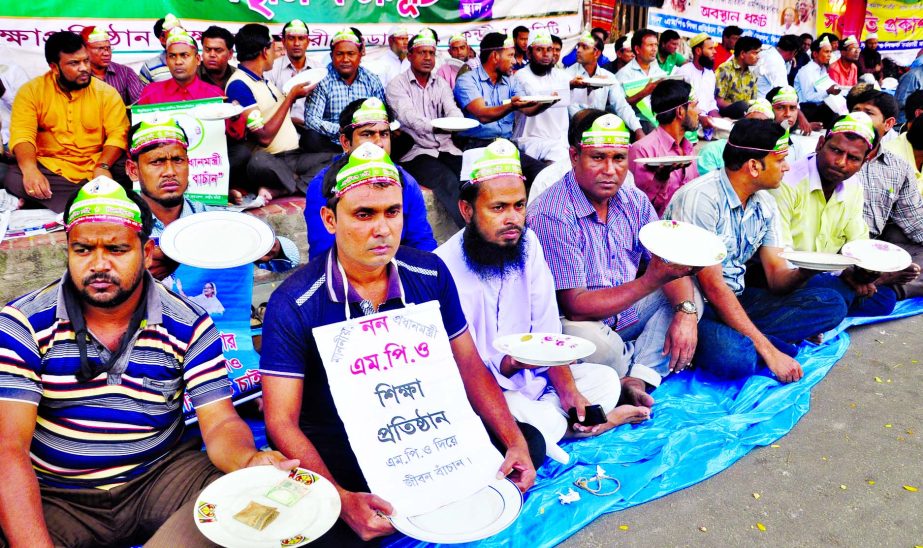 Non-MPO teachers continue sit-in with a fresh move reiterating their demand on 18th consecutive day on Thursday for inclusion in MPO list. Photo shows teachers seen with empty plates and wearing caps like beggars in front of Jatiya Press Club on Thursday.