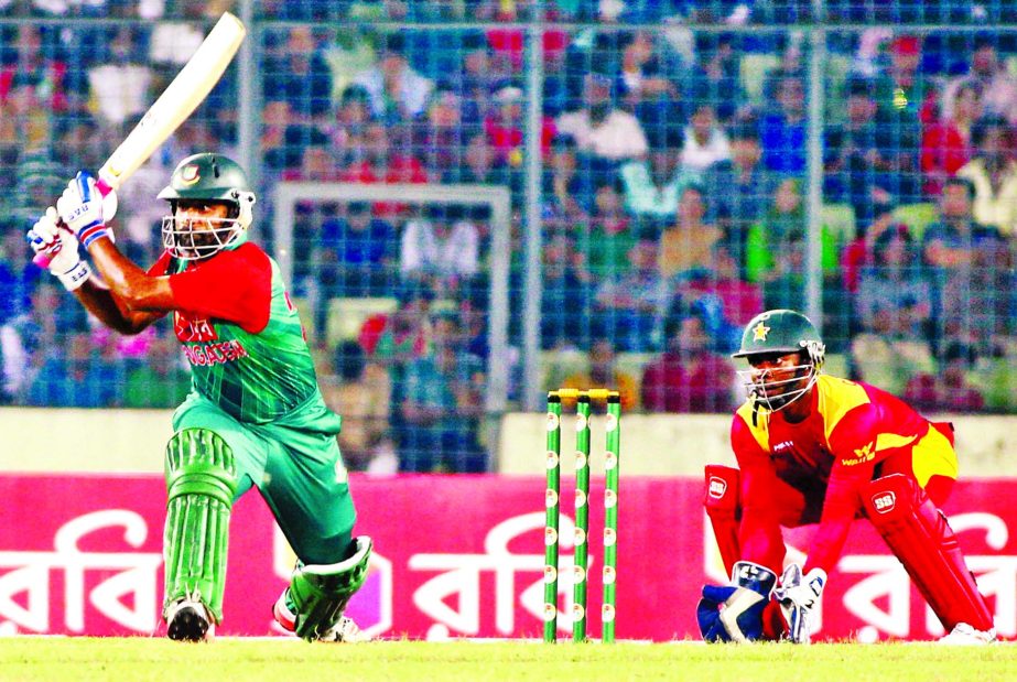 Dashing opener Tamim Iqbal hits a shot while wicketkeeper Regis Chakabva looks on during the first Twenty20 International match between Bangladesh and Zimbabwe at the Sher-e-Bangla National Cricket Stadium in Mirpur on Friday.