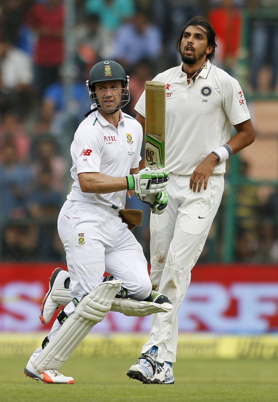 South Africa's AB de Villiers (left) and India's Ishant Sharma watch the ball after Villiers played a shot during the first day of their second cricket Test match in Bangalore, India on Saturday.