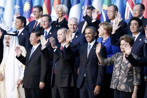 Members of the Group of 20 (G20) wave during the traditional family photo at the G20 leaders summit in the Mediterranean resort city of Antalya, Turkey on Monday.