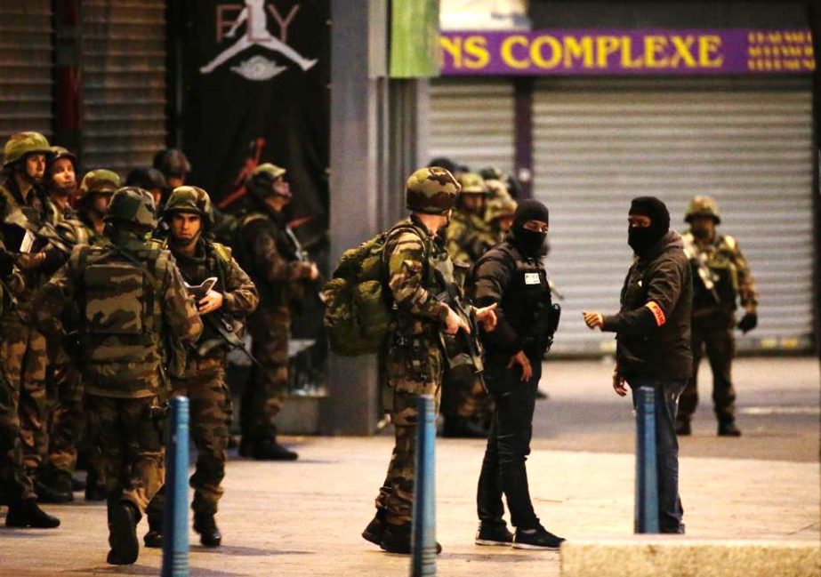 French soldiers and members of police special forces stand guard in the northern Paris suburb of Saint-Denis city center, on Wednesday, during an anti-terror operation.