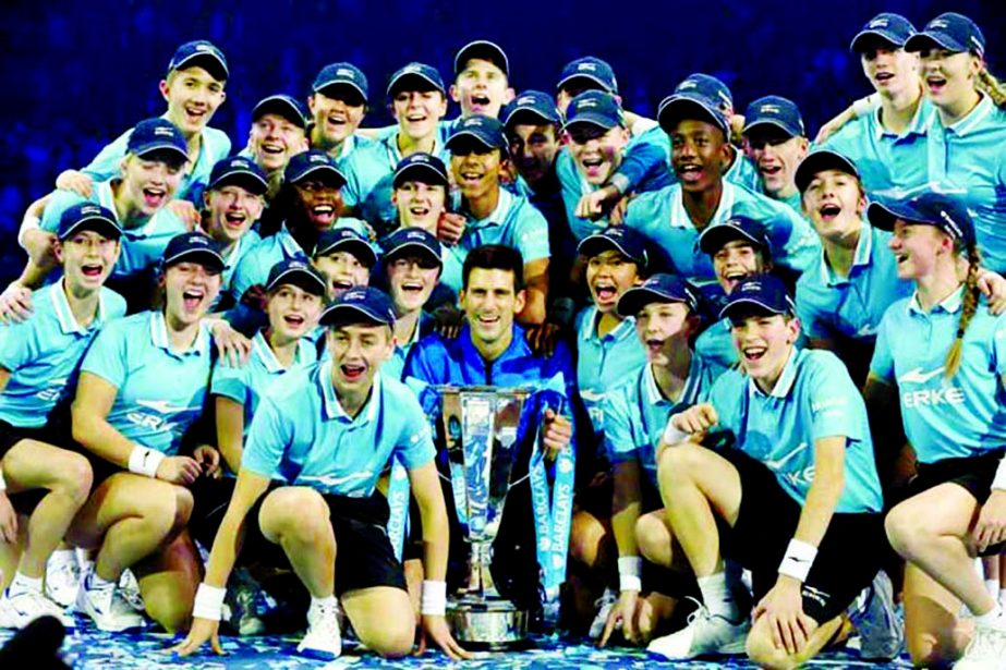Novak Djokovic of Serbia poses for a picture with the Barclays ball kids and the winners trophy after he defeated Roger Federer of Switzerland in their singles final tennis match at the ATP World Tour Finals, in the O2 arena in London on Sunday.