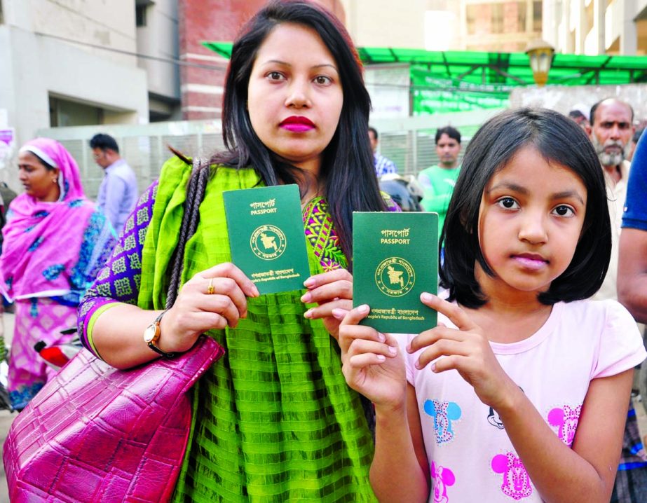 Mother and her daughter showing their Machine Readable Passports after receiving the Passports from Agargaon office in the city on Monday.