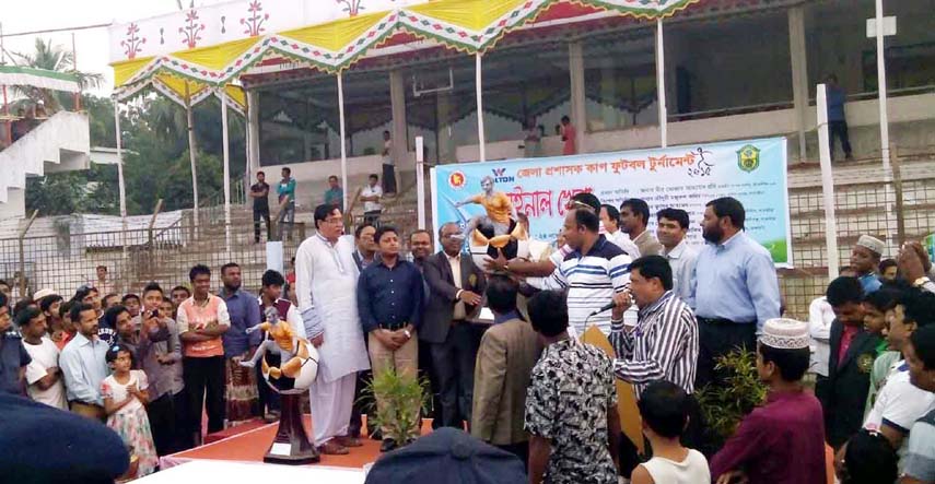 . Member of Jatiya Sangsad Mir Mostaq Ahmmed Robi handing over the championship trophy of the Walton District Commissioner Cup Football Tournament (Satkhira) to the team leader of Kaliganj Upazila at the Satkhira District Stadium on Tuesday.