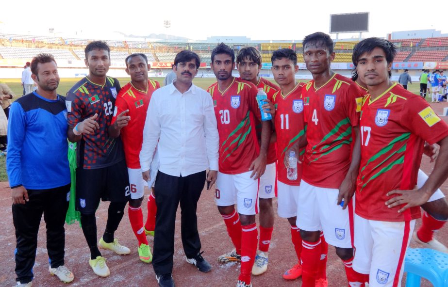 Members of Bangladesh National Football team pose for a photo session after beating Heibei Football team of China by a solitary goal at the Mang Shi City Stadium in China on Tuesday.