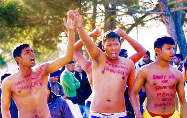 Migrants and refugees from Bangladesh demonstrate in front of Macedonian policemen as they wait to cross the Greek-Macedonian border near Gevgelija.