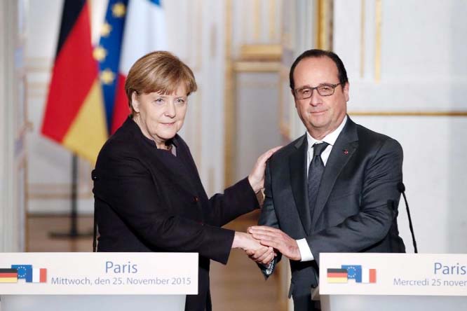 French President Francois Hollande (R) shakes hands with German Chancellor Angela Merkel after a joint press conference at the Elysee Presidential Palace in Paris on Wednesday.