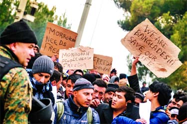 Frustrated migrants from Bangladesh and Morocco protest not being allowed to cross the border by holding placards. Internet photo