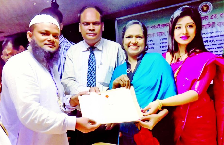 Director of Ain Shahayata Kendra (ASOK), Photo Journalist Md Mosharraf Hossain Raju (left) receiving award and certificate from Mahbubul Alam Sheikh Russel, a Director of Ansar and VDP Unnayan Bank recently. A workshop jointly organized by National Prod