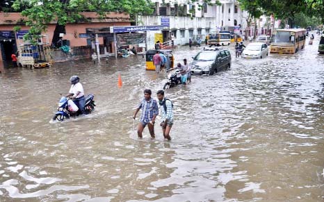 People wade through a flooded street in Chennai, in the southern Indian state of Tamil Nadu on Friday.