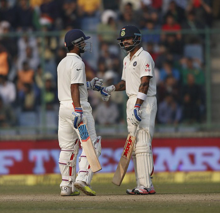 India's captain Virat Kohli (right) and batsman Ajinkya Rahane (left) punch-gloves on the third day of the fourth Test cricket match between India and South Africa in New Delhi, India on Saturday.