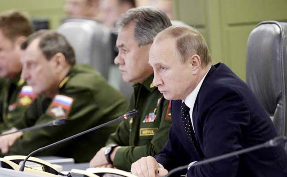 Russian President Vladimir Putin (R) with Defence Minister Sergei Shoigu (C) attend a meeting on Russian air force's activity in Syria.