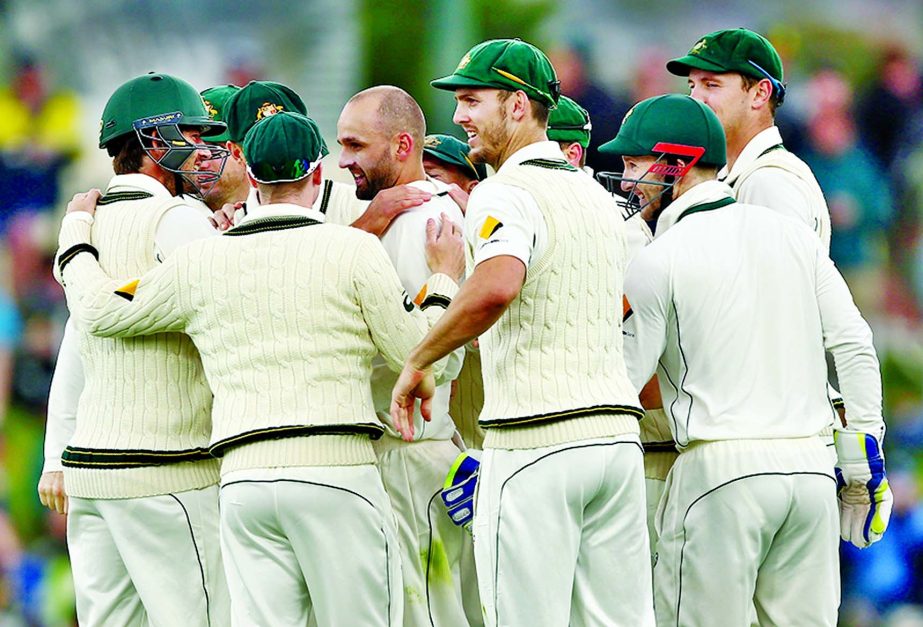 Team-mates mob Nathan Lyon after he dismissed Jermaine Blackwood on the 2nd day of 1st Test between Australia and West Indies at Hobart on Friday.