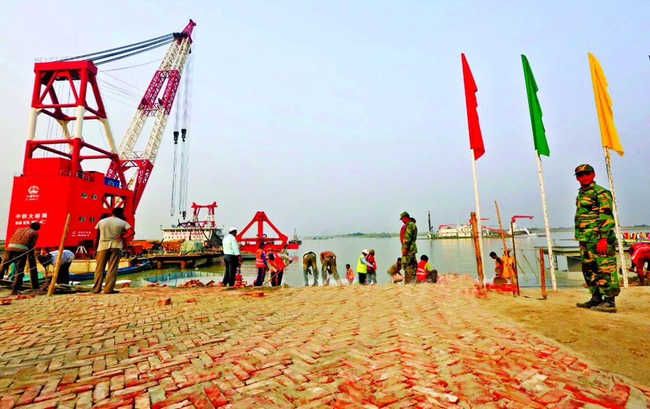 Workers an technicians passing busy days prior to Prime Ministerâ€™s opening of Padma Bridge approach roads, piling and river training works. This photo was taken from Jajira end on Friday.
