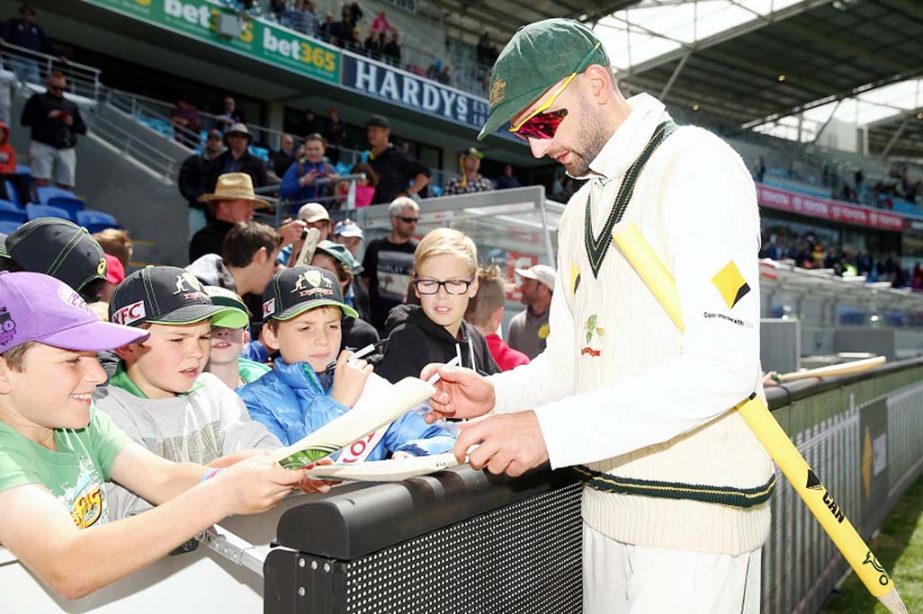 Nathan Lyon giving autograph to his tiny fans after a massive victory against West Indies on the 3rd day of 1st Test at Hobart on Saturday.