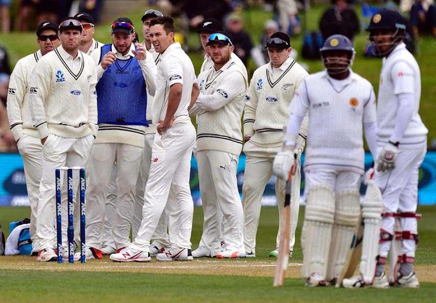 Rangana Herath (2R) of Sri Lanka watches the DRS screen, after challenging an LBW call, as team mate Milinda Siriwardana (R), and the New Zealand team look on during day three of the first International Test cricket match between New Zealand and Sri Lanka