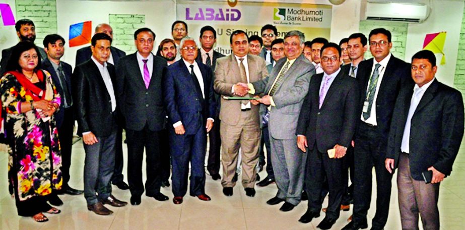 Md. ShafiulAzam, Additional Managing Director of Modhumoti Bank Limited and Al Emran Chowdhury, Chief Operating Officer of Labaid Group exchanging deal documents at the Bank's Head Office premises in the city on Sunday. Md. Mizanur Rahman, Managing Direc
