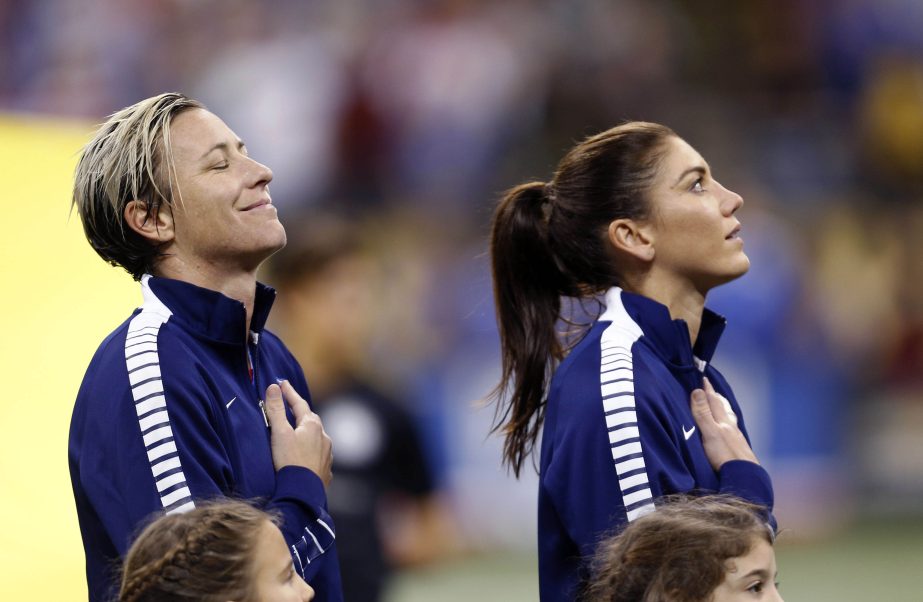 US forward Abby Wambach (left) smiles during the playing of the national anthem before the team's international friendly soccer match against China in New Orleans on Wednesday. At right is goalie Hope Solo.