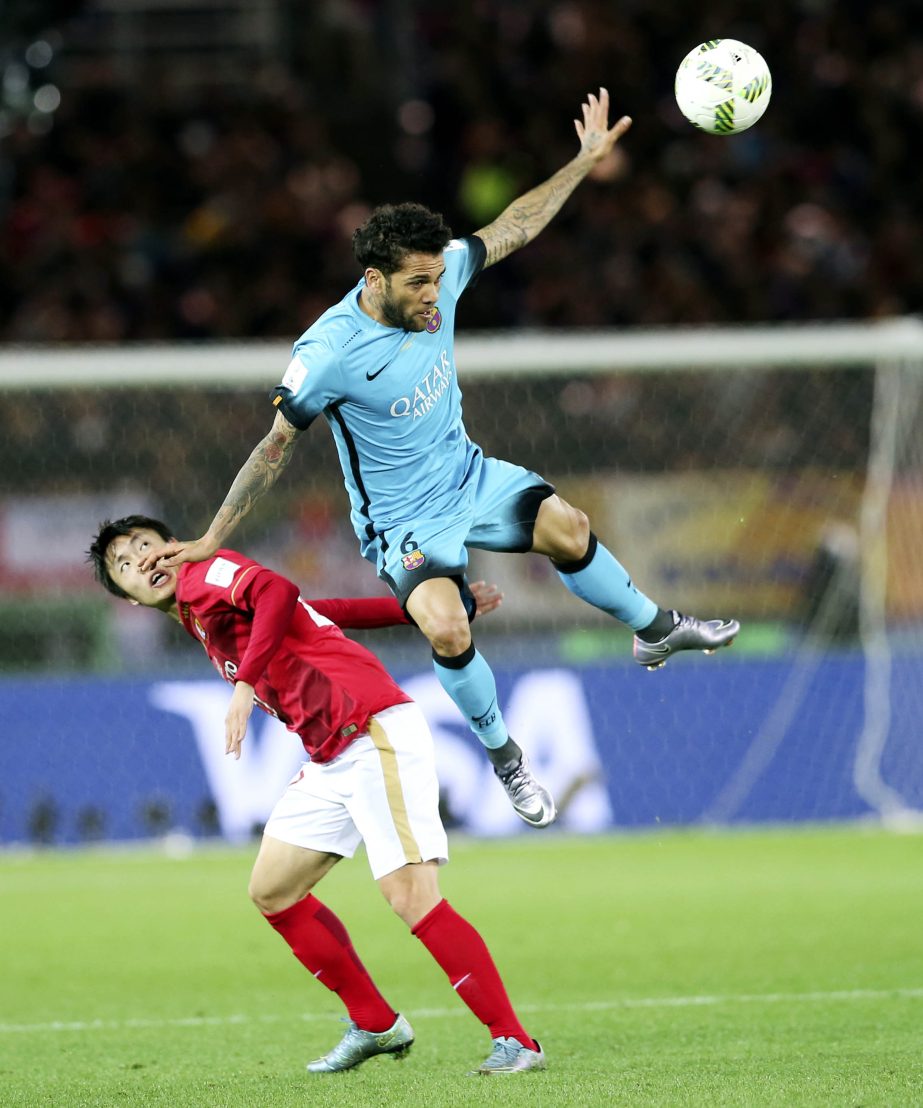 FC Barcelonaâ€™s Dani Alves (right) of Brazil and Guangzhou Evergrande FCâ€™s Zou Zheng battle for the ball during their semifinal match at the FIFA Club World Cup soccer tournament in Yokohama, near Tokyo on Thursday.