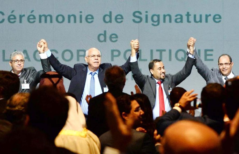 Libya's GNC Deputy President Saleh al-Makhzoum (C-R) and head of the Tobruk-based House of Representatives Mohamed Ali Shoeb (C-L) with GNC members Nouri Abar (R) and Fethi Bachar (L) celebrate after signing a deal on Thursday in Skhirat.