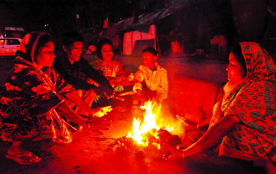 Cold-stricken city-dwellers warming themselves with straw fire due to the sudden appearance of bone-chillying cold. This photo was taken from Kamalapur area on Friday.