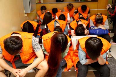 Cyber crime suspects from Taiwan and China sit as they wait for deportation at an immigration detention center in Jakarta, Indonesia on Wednesday