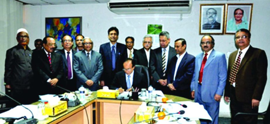 Mohammad Ismail, Chairman of the Board of Directors of Bangladesh Krishi Bank, signing its balance sheet for the year of 2015 at the 652nd board meeting at the bank's head office on Tuesday. M A Yousoof, Managing Director of the bank was present.