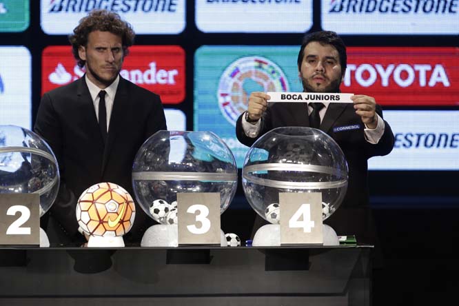 Conmebol Secretary Hugo Figueredo (right) holds a ballot with the name of Argentina's Boca Juniors, as Uruguay's Diego Forlan stands by during the Copa Libertadores draw ceremony in Luque, Paraguay on Tuesday.