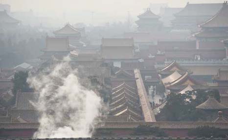 Steam rises behind a wall of the Forbidden City, once the home of China's emperors, on a polluted day in Beijing